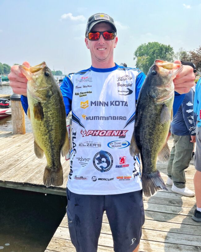 Glenn Walker holding up two largemouth bass from a BFL event.